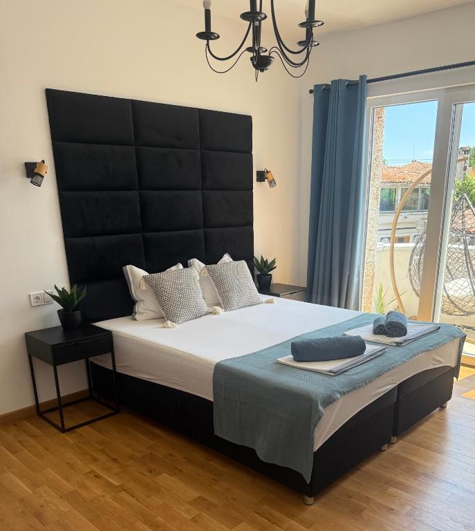 a bedroom with a large bed with a black headboard at Holiday Apartment ORA in Balchik