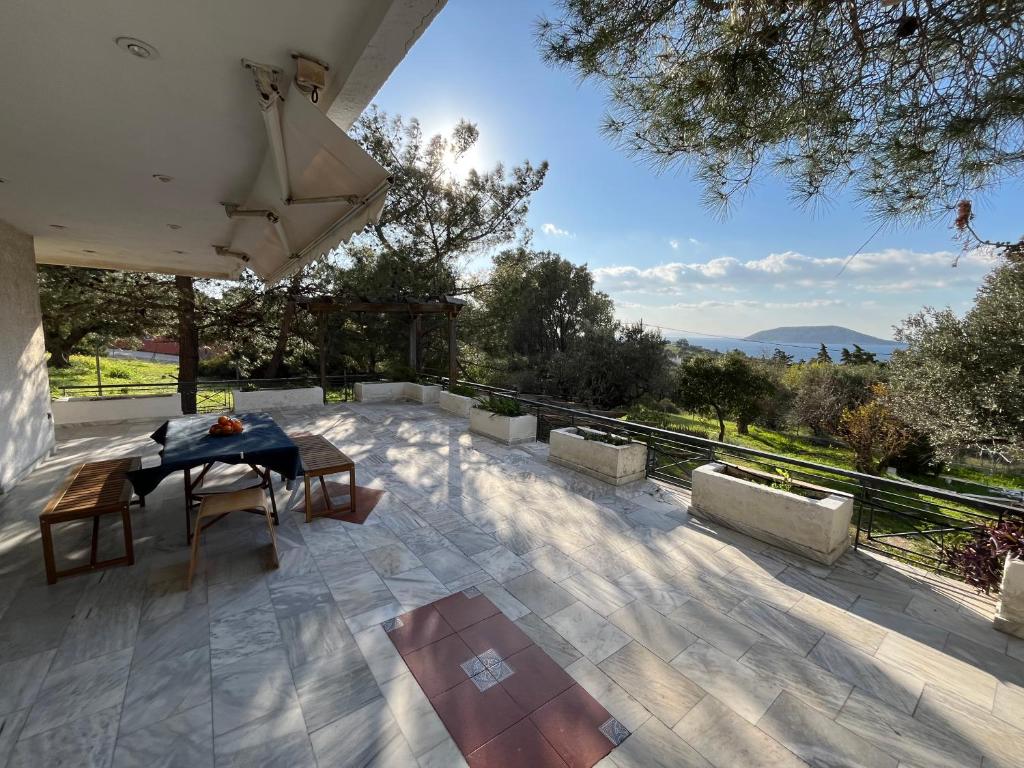 eine Terrasse mit einem Tisch und Stühlen sowie Aussicht in der Unterkunft Seaview Haven in Kap Sounion