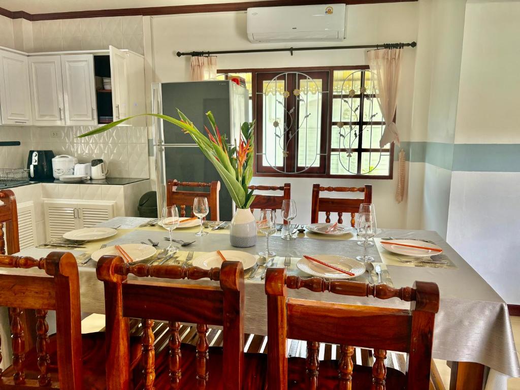 ein Esszimmer mit einem Tisch und Stühlen sowie eine Küche in der Unterkunft Amazing 4BR pool villa near beach Bangtao in Ban Thalat Choeng Thale
