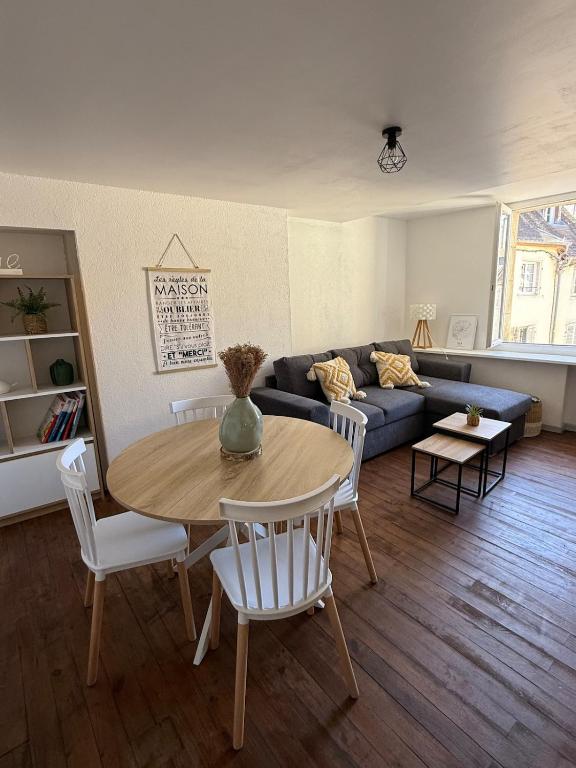 a living room with a table and a couch at Le Nid Dolois in Dole
