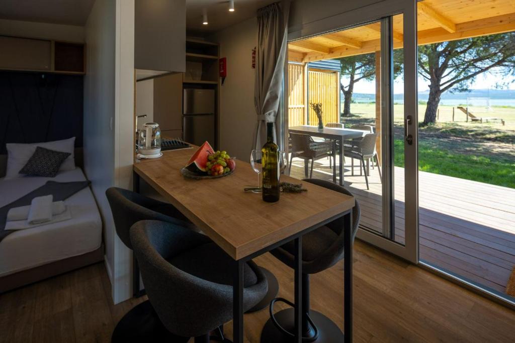 una pequeña cocina con mesa y sillas en una habitación en Mobilna kućica Lux, en Turanj