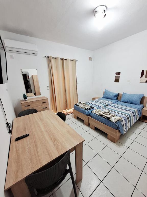 a bedroom with a bed and a wooden table at Lovely Paceville Studio D in St. Julianʼs