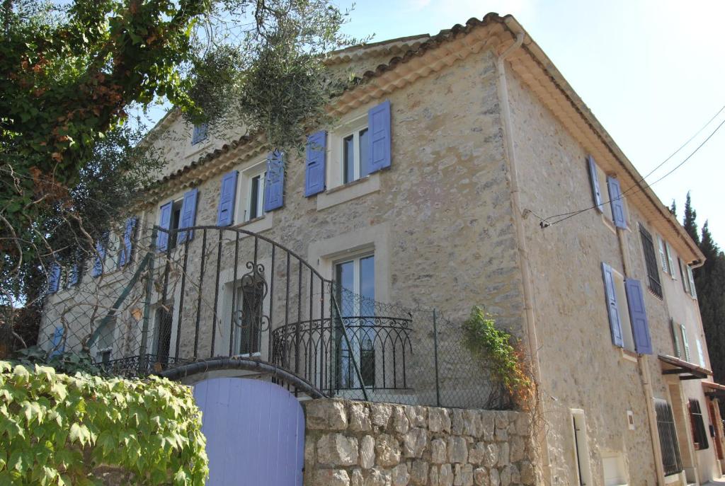 a stone house with a gate and a balcony at " Le cottage " in Mouans-Sartoux