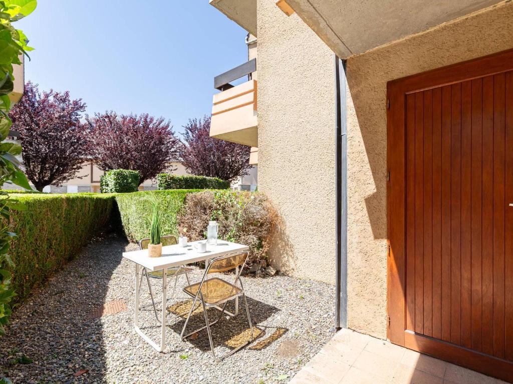 une petite table à côté d'un bâtiment avec une porte dans l'établissement Appartement T2 avec jardinet, parking et casier à skis, quartier thermal, proche télécabine, 2 étoiles - FR-1-296-171, à Saint-Lary-Soulan