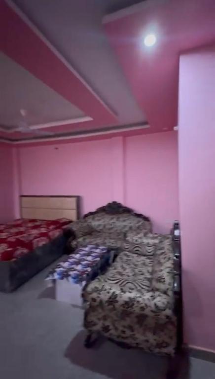 two beds in a room with pink walls at Rishi home stay in Bhauli