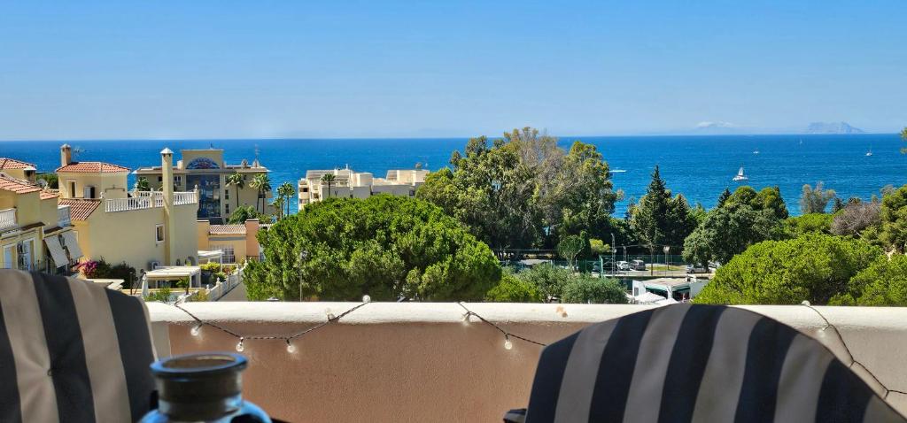 balkon z 2 krzesłami i widokiem na ocean w obiekcie Dúplex con vistas al mar, playa y puerto a pasos w mieście Estepona