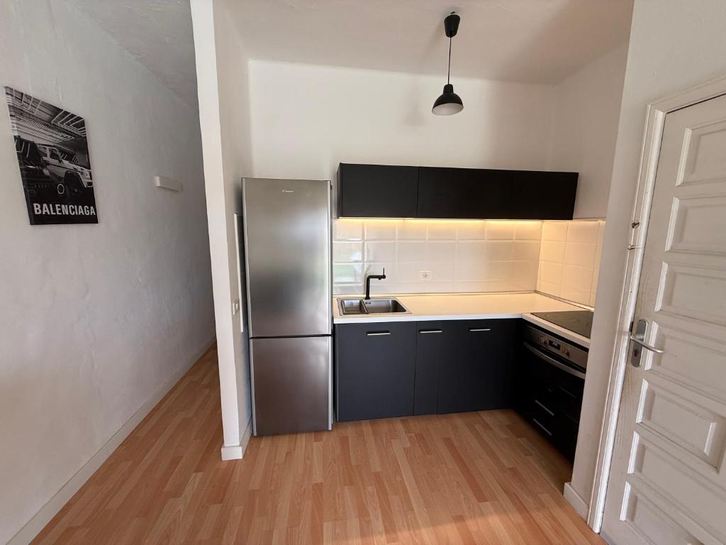 een keuken met een roestvrijstalen koelkast in een kamer bij bonito y acogedor apartamento in Famara