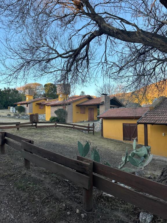 una valla de madera delante de una casa en Cabañas Los Gauchitos, en La Falda