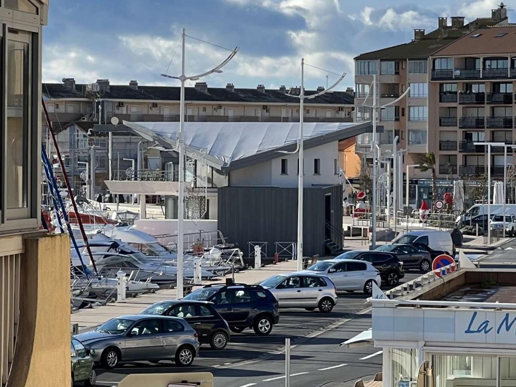 un parking avec des voitures garées dans une ville dans l'établissement Appartement T2 proche centre, 6 pers. avec balcon, ascenseur, à 400m de la plage et 200m des commerces - FR-1-701-38, à Valras-Plage