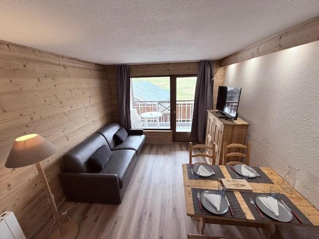 un salon avec un canapé et une table dans l'établissement Studio ensoleillé avec coin montagne et balcon, face aux pistes de Montgenèvre - FR-1-266-130, à Montgenèvre