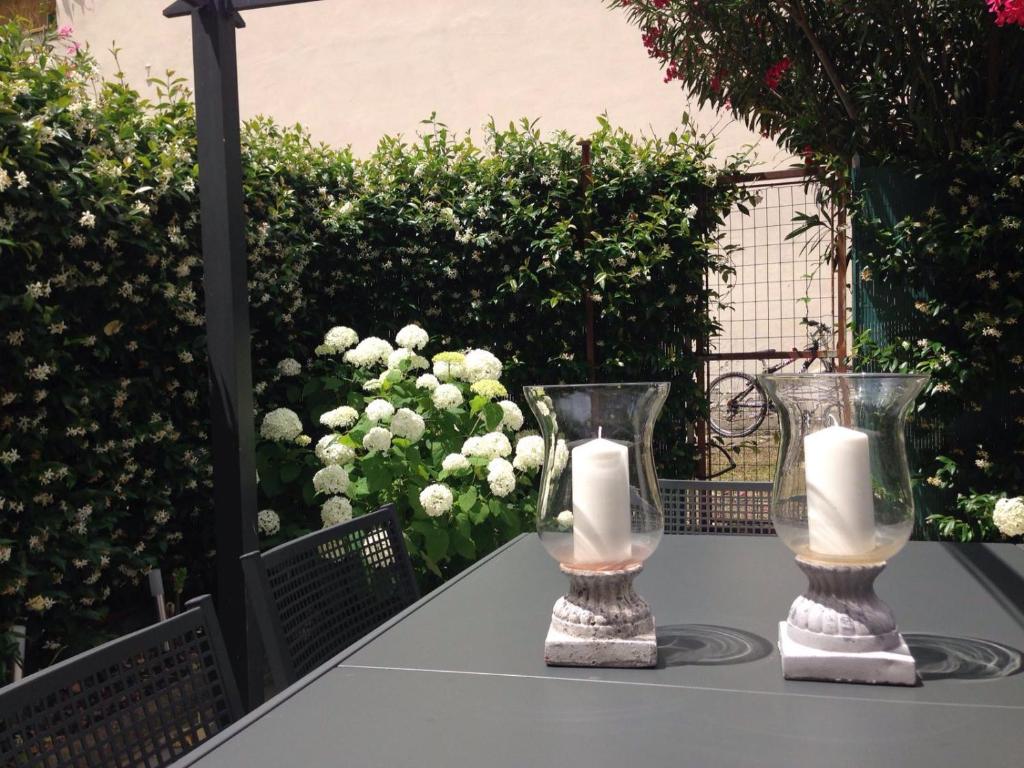 フィレンツェにあるCasa Rinucciniの花のテーブルにキャンドルが置かれたガラスの花瓶2枚