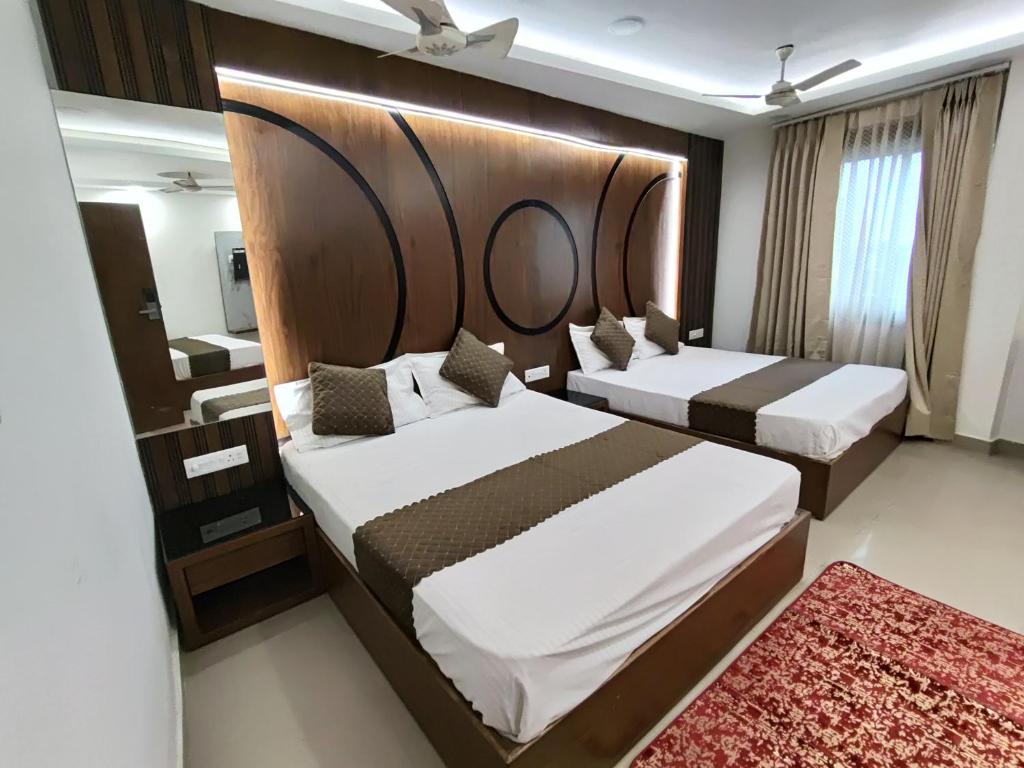 a bedroom with two beds and a large headboard at Hotel Muskan in Mathura