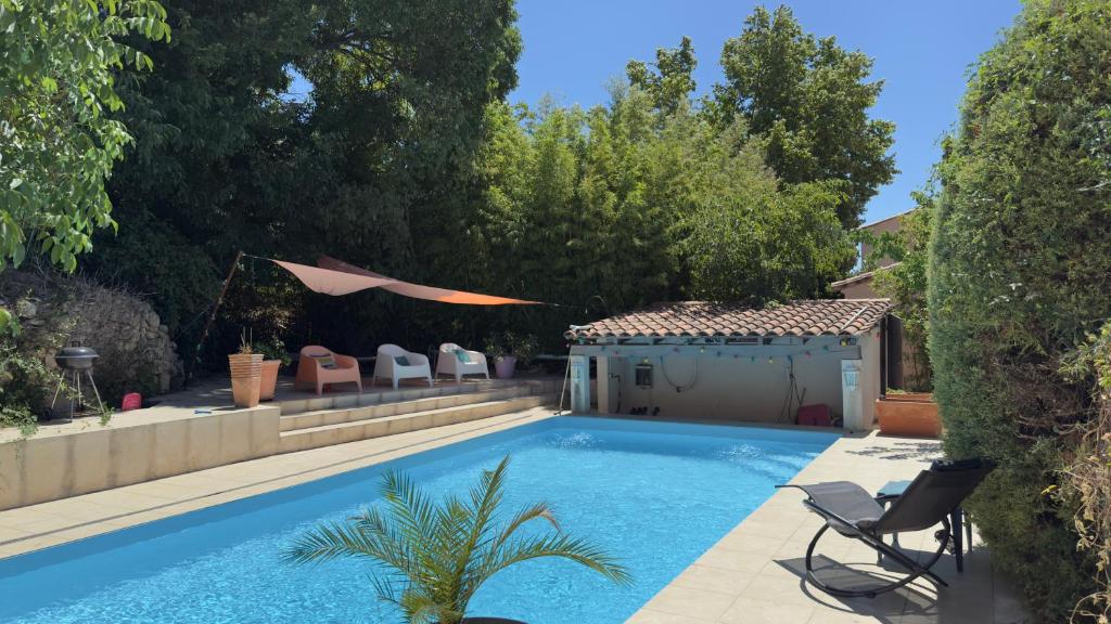 une piscine dans une cour avec une maison dans l'établissement L’appartement du Micocoulier, à Salon-de-Provence
