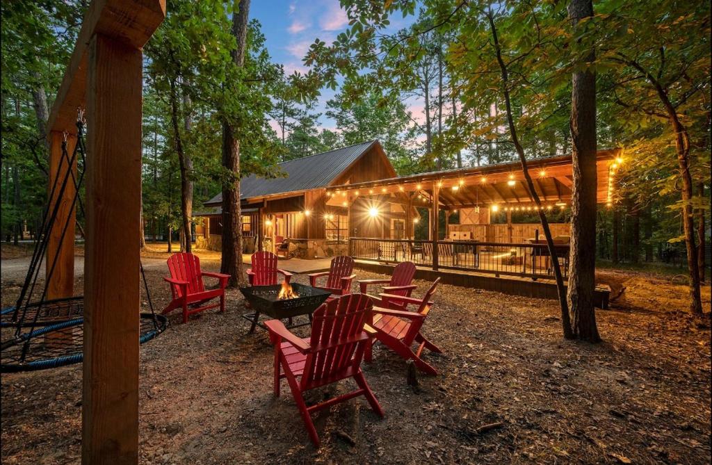 a group of chairs and a table in front of a cabin at Close to All, Mini Golf, Hot Tub, Fire-Pit, Swing Set in Broken Bow