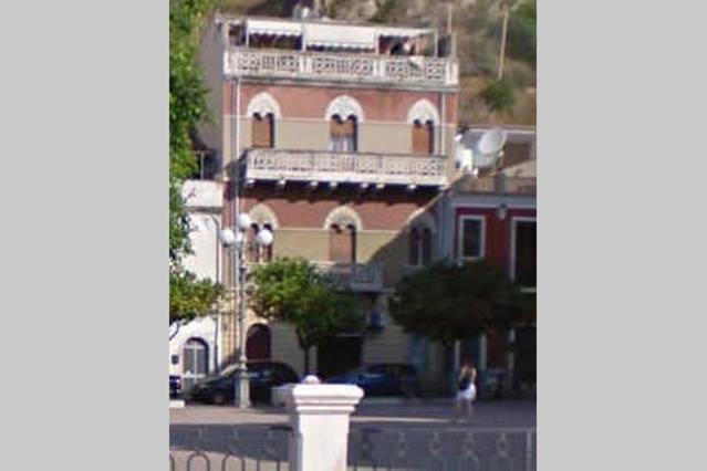 a large building with a balcony on top of it at Casa Vacanze Corso Umberto in Giardini Naxos
