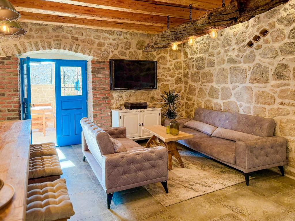 a living room with two couches and a tv at NEW! Holiday Home Retro Stone House in Živogošće