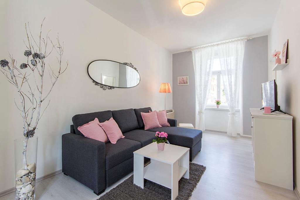a living room with a black couch and pink pillows at Center Apartment Tina in Pula