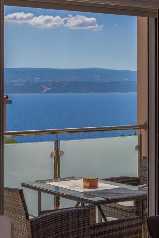 a balcony with a table and a view of the water at Casa Moderna - New Spacious Apartments in Lokva Rogoznica