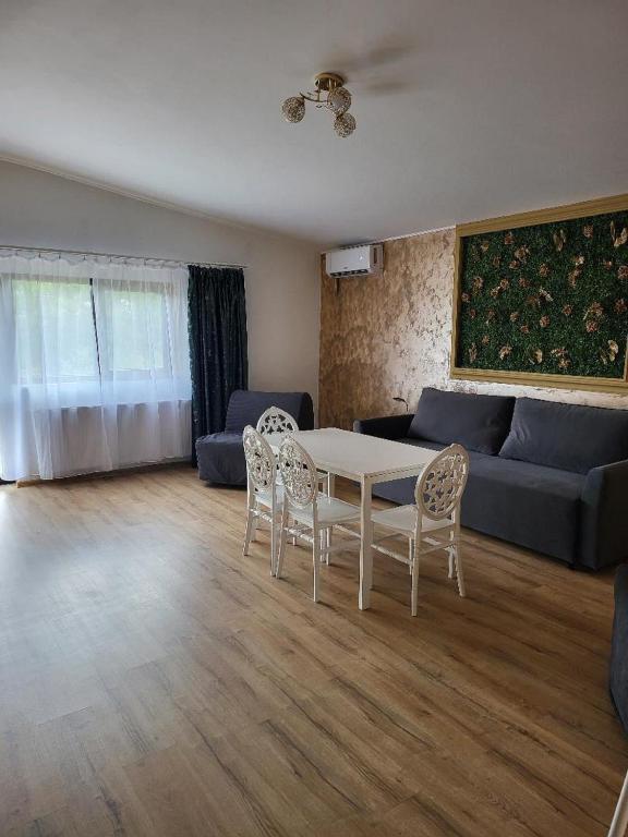 a living room with a table and chairs and a couch at Casa Ratiu 3 Stele Airport Bucharest Therme Bucharest in Baloteşti
