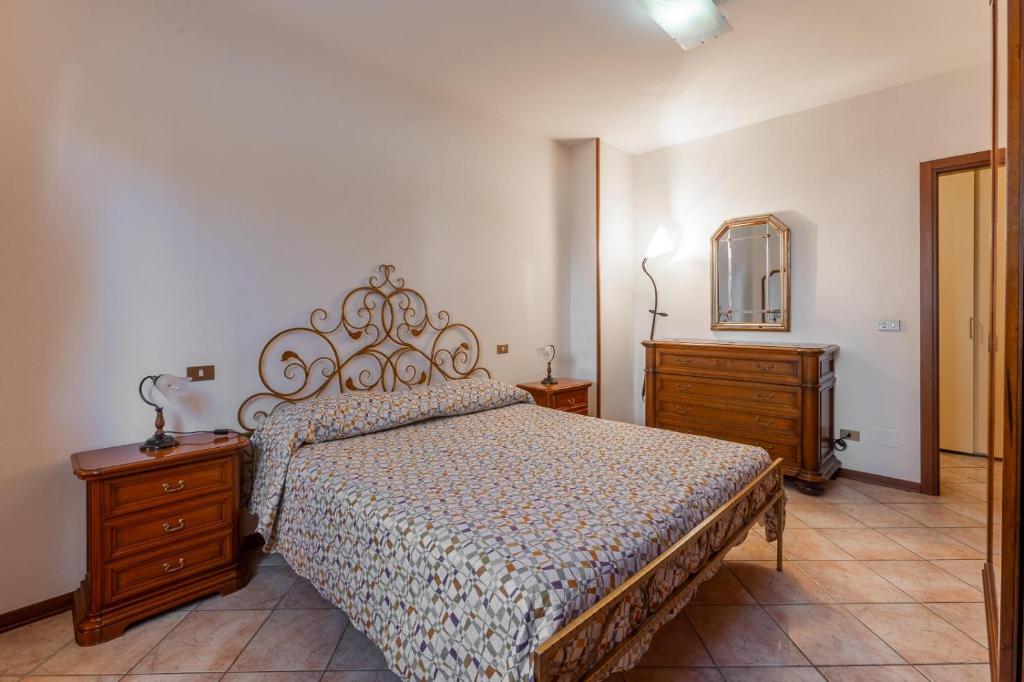 a bedroom with a bed and two dressers and a mirror at La Casa di Nadia in Bussolengo