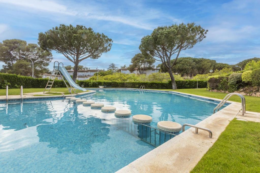 una piscina con scivolo in un cortile di La Paloma a Palafrugell