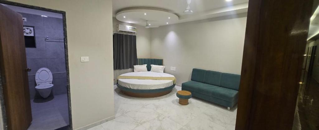 a bathroom with a bed and a couch in a room at Hotel Avanue Villa in Dabhoi