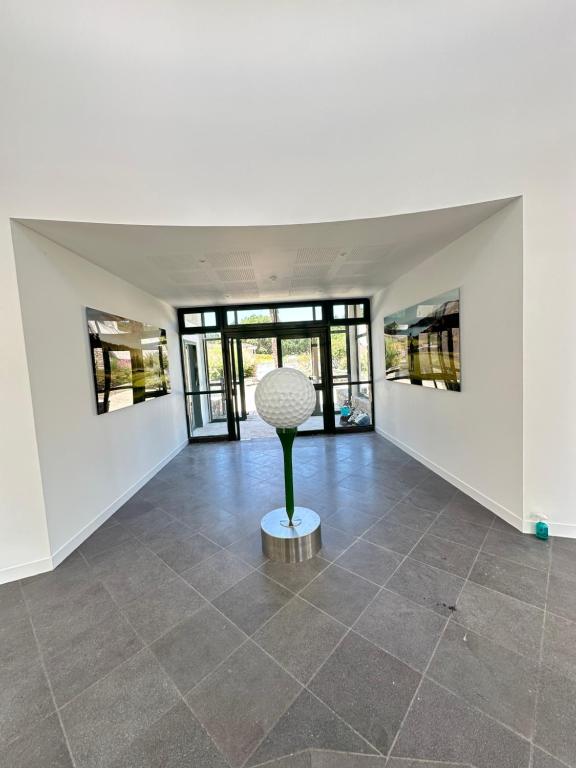 a room with a sculpture on a tiled floor at Écrin Neuf au Cœur du Golf in Saint-André-des-Eaux