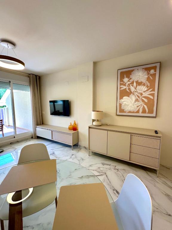 a living room with a table and chairs and a television at Playa Sol 2 in Denia