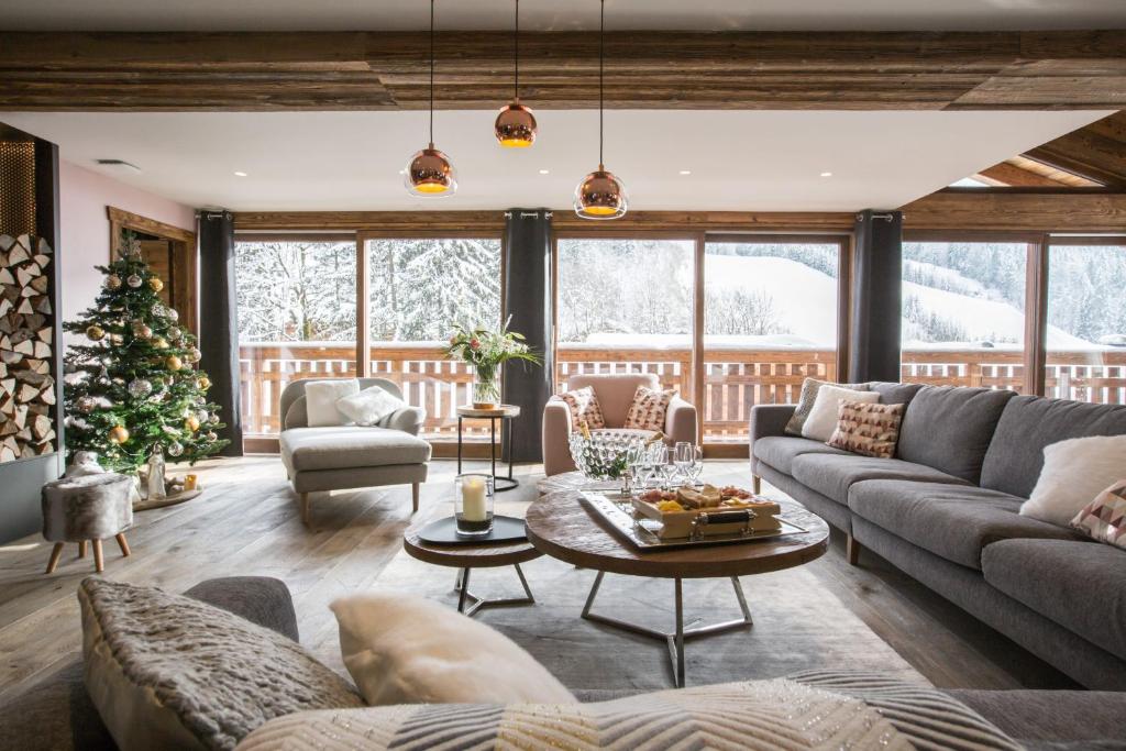 - un salon avec un canapé et un arbre de Noël dans l'établissement Chalet Le Saint-Jean - 15 pers - proche pistes, aux Gets