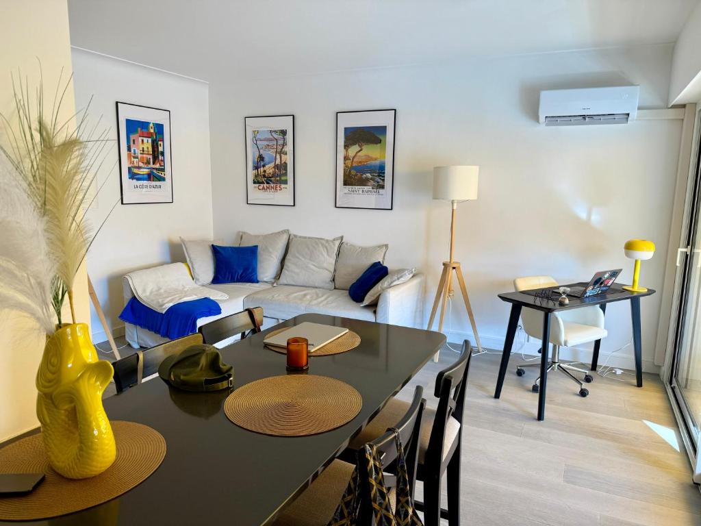 un salon avec une table et un canapé dans l'établissement Cannes Centre - Sea View - Modern - Walking Distance Beach and Palais des Festivals, à Cannes