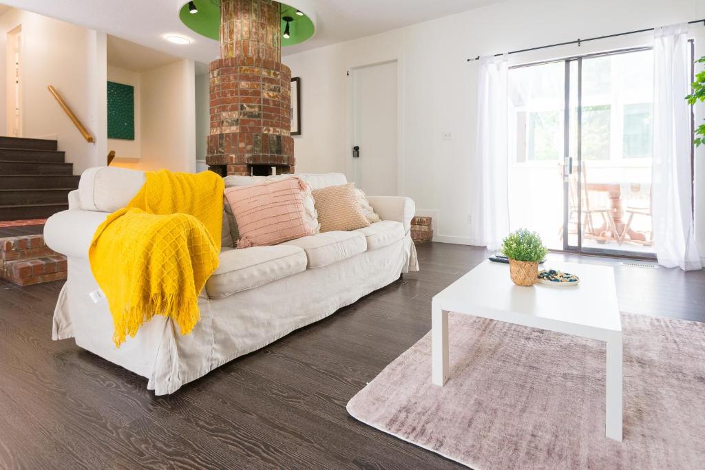 a living room with a white couch and a table at Bright & Spacious House Near UBC in Vancouver
