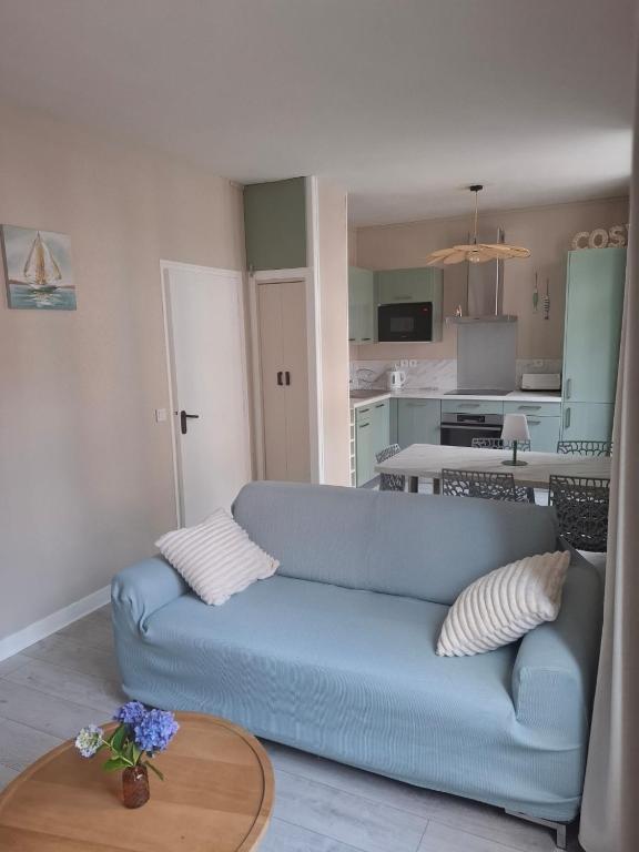 un salon avec un canapé bleu et une table dans l'établissement Le Cosy, à Mers-les-Bains