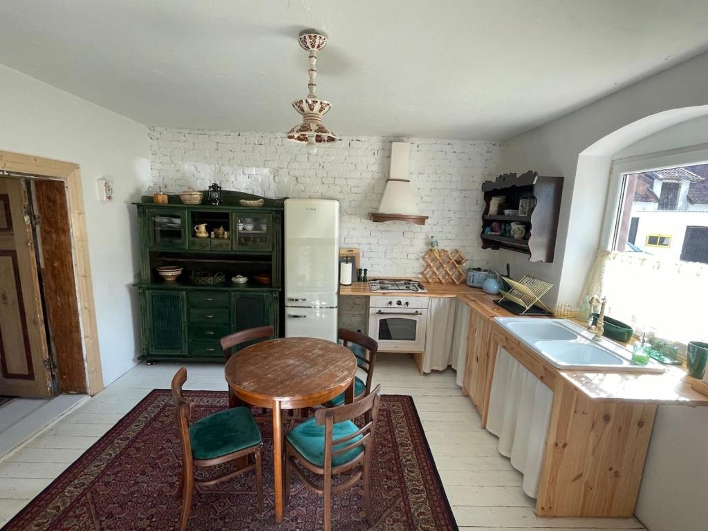 a kitchen with a table and a refrigerator at Mieszkanie niedoskonałe in Pniewo