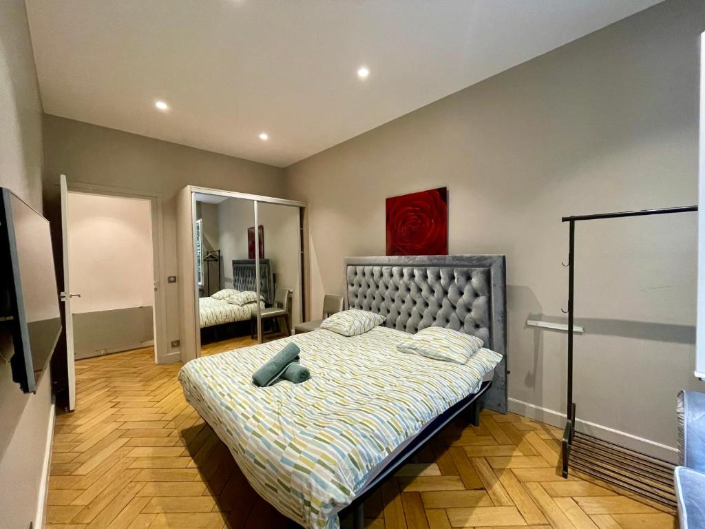une chambre avec un lit et un miroir dans l'établissement Appartement Tour Eiffel Montaigne, à Paris