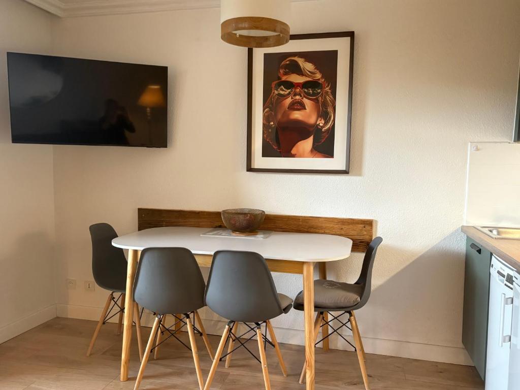 une table et des chaises dans une cuisine avec une photo sur le mur dans l'établissement Pierre et Vacances Les Bergers au Pied des pistes & Piscine -Sauna & Balcon Sud, à L'Alpe-d'Huez