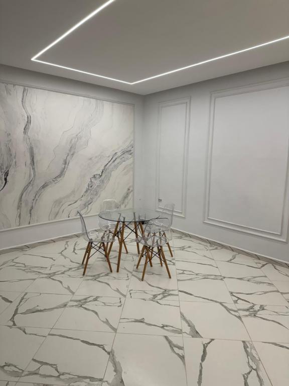 une salle à manger avec une table et des chaises et un sol en marbre dans l'établissement AL MIDIAF STYLISH VILLA &Garage, à Mostaganem