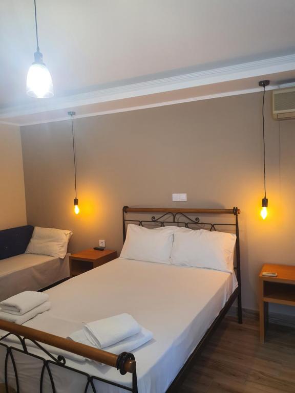 a bedroom with a bed and a couch and lights at Magda in Loutra Edipsou