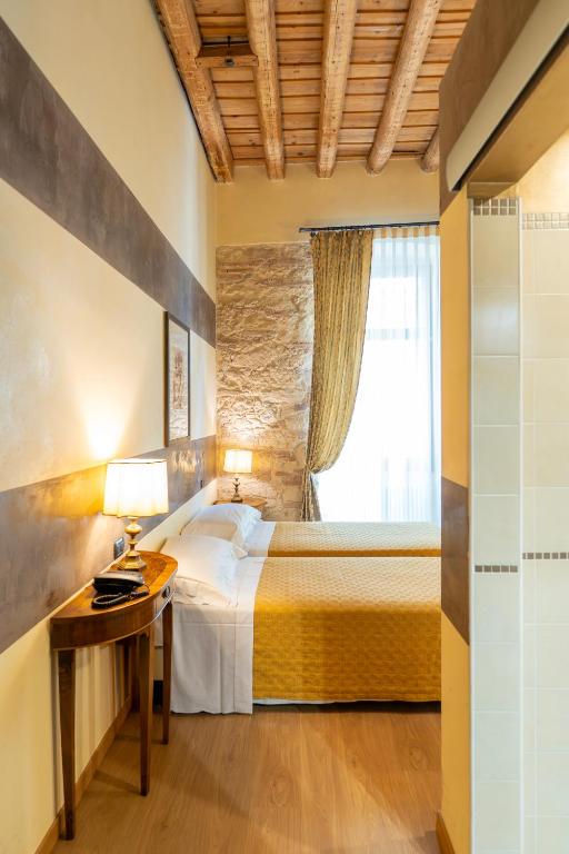 ヴェローナにあるBoutique Hotel Scalzi - Adults Onlyのベッドと机と窓のある寝室