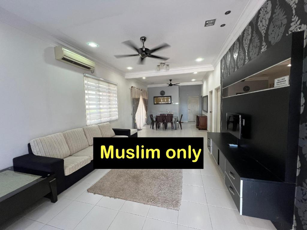 a living room with a couch and a tv at Almai Homestay Batu 4 in Port Dickson