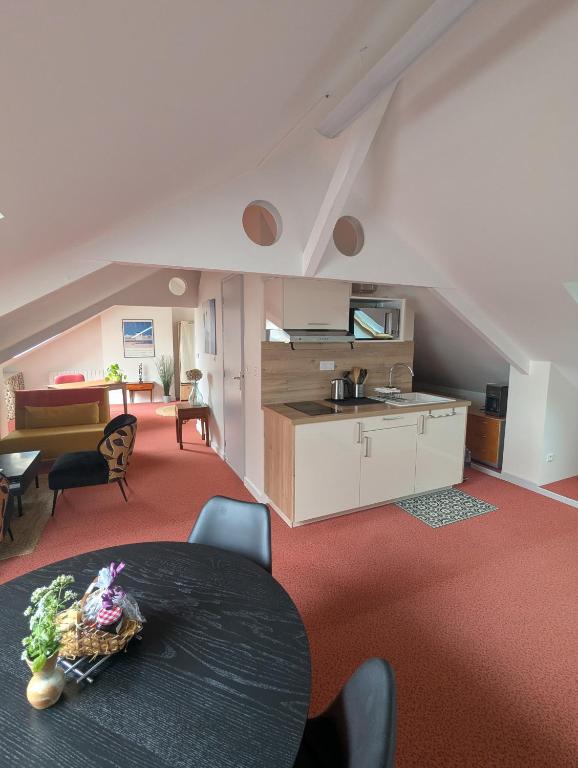 un salon avec une table et une cuisine dans l'établissement Studio idéalement situé au cœur de la ville et des activités, à Loudéac