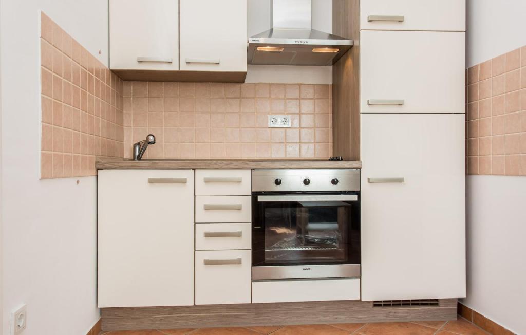 a kitchen with white cabinets and an oven at Nives in Šilo