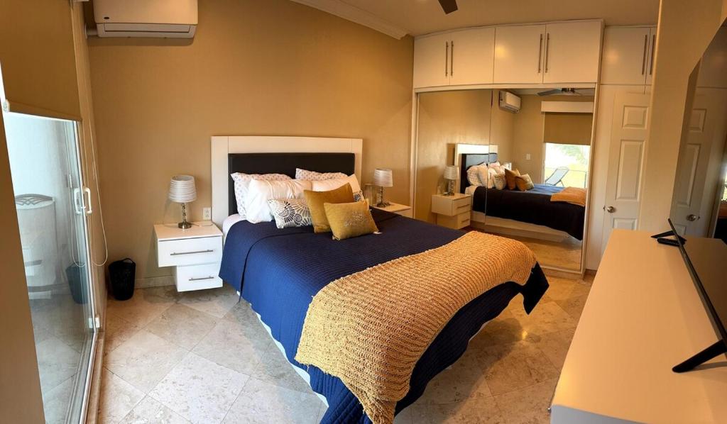 a bedroom with a large bed with a blue blanket at Palapa House in Tijuana