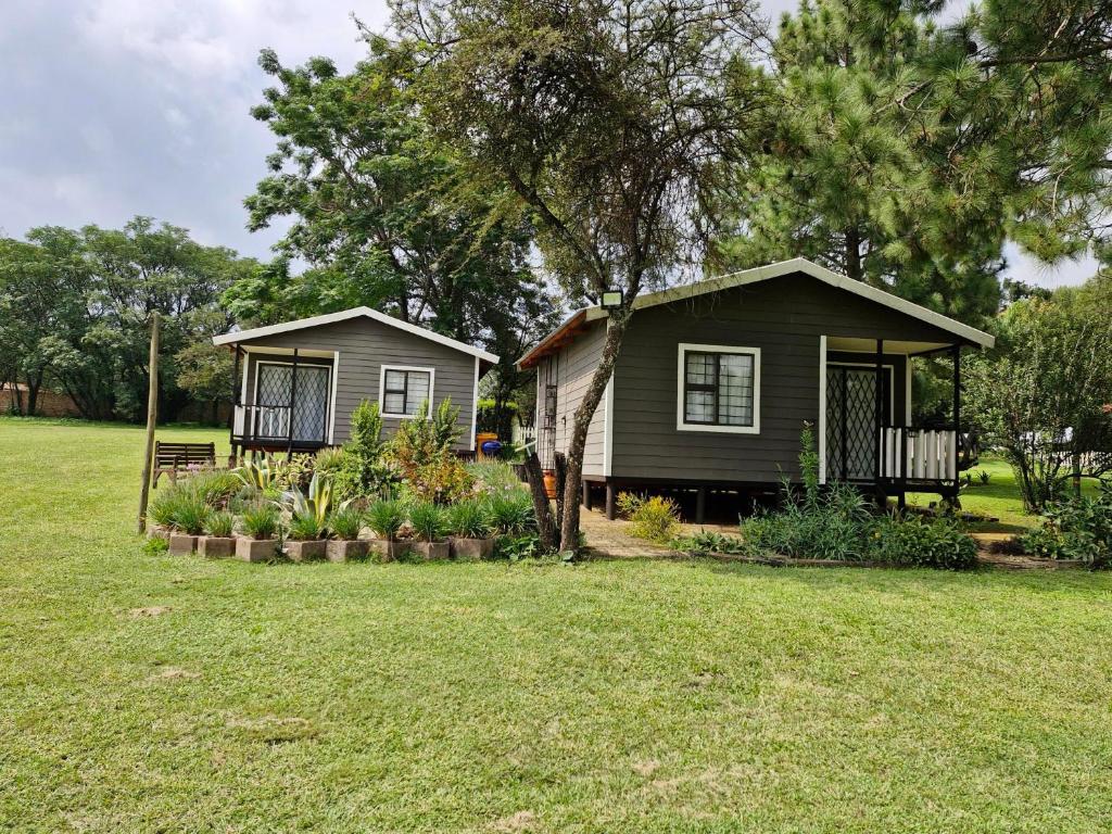 a small house in a field with a yard at Elmscote Cottages - Cabin 2 in Krugersdorp