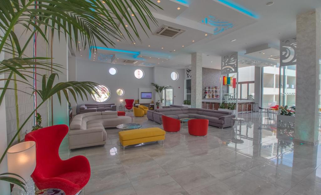 a lobby with couches and chairs and a plant at Nicholas Color Hotel in Ayia Napa