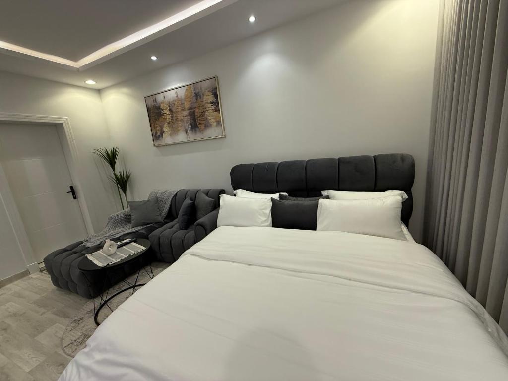 a bedroom with a large bed and a couch at شقة تأجير يومي استوديو جديد بأثاث هادئ وأنيق in Riyadh