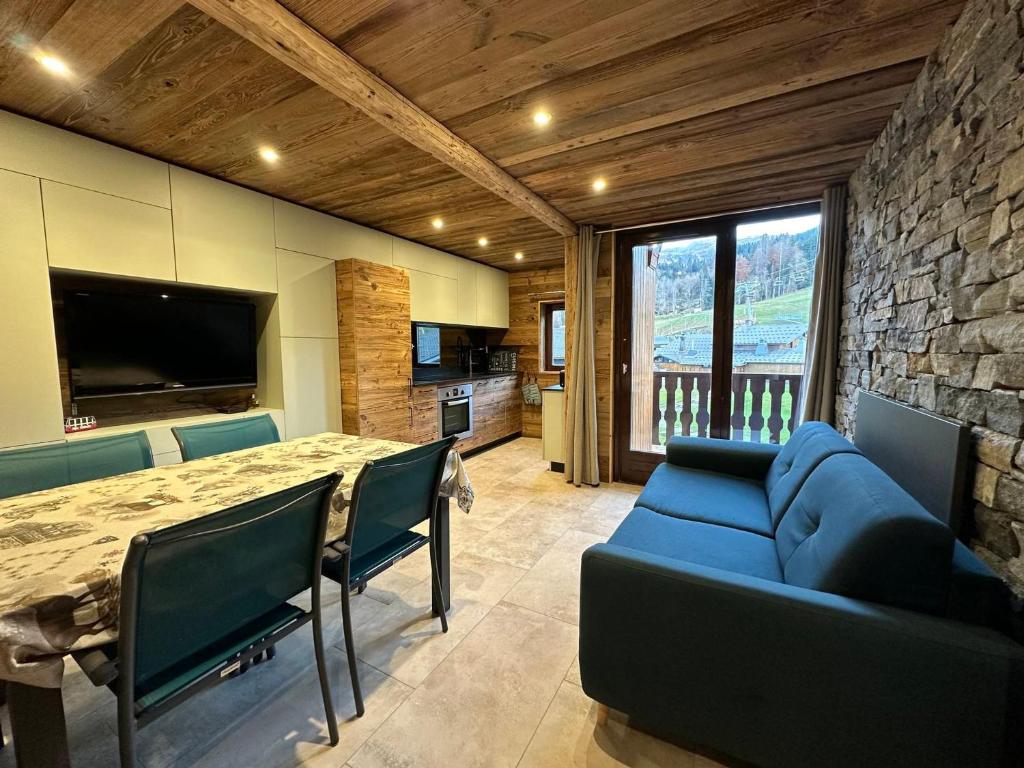un salon avec un canapé bleu et une table dans l'établissement Duplex rénové 6p au pied des pistes, expo sud, balcon et wifi à Morillon - FR-1-642-56, à Morillon