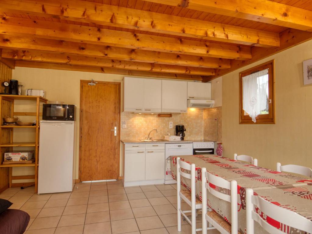 una cucina con un tavolo e sedie in una stanza di Chalet cosy à Morillon, 2 salles de bain, parking, Wifi, près du lac - FR-1-642-42 a Morillon