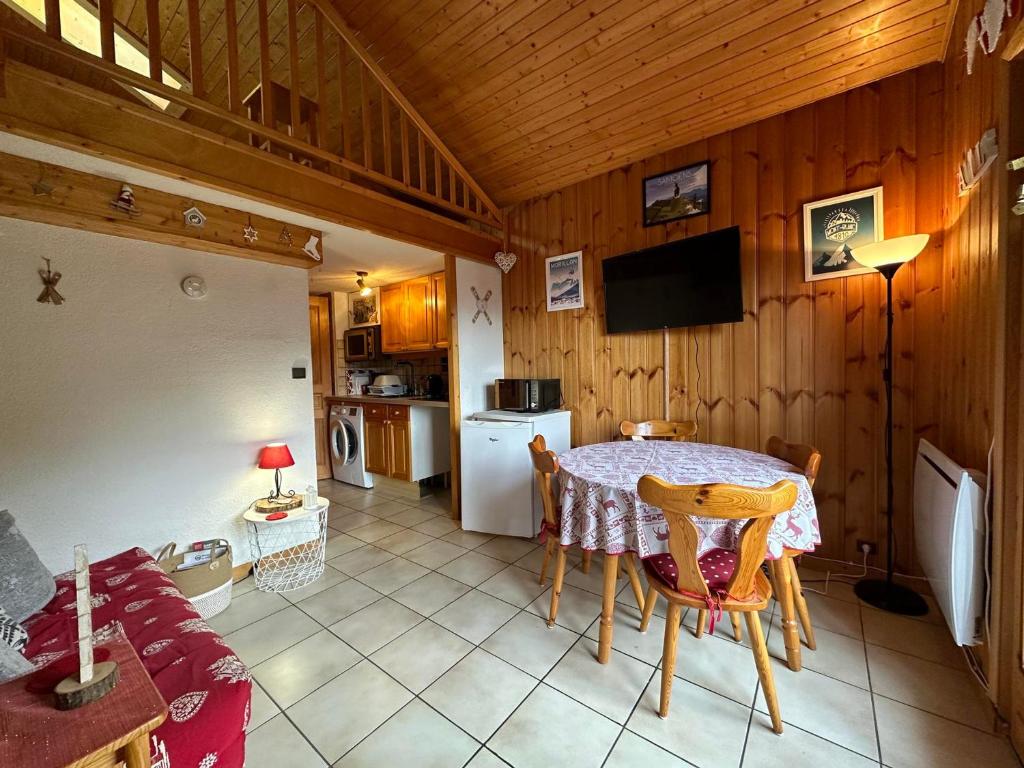 une salle à manger avec une table et une cuisine dans l'établissement Duplex charmant au cœur de Morillon, près lac et navette, 5 pers, balcon, équipement complet - FR-1-642-99, à Morillon