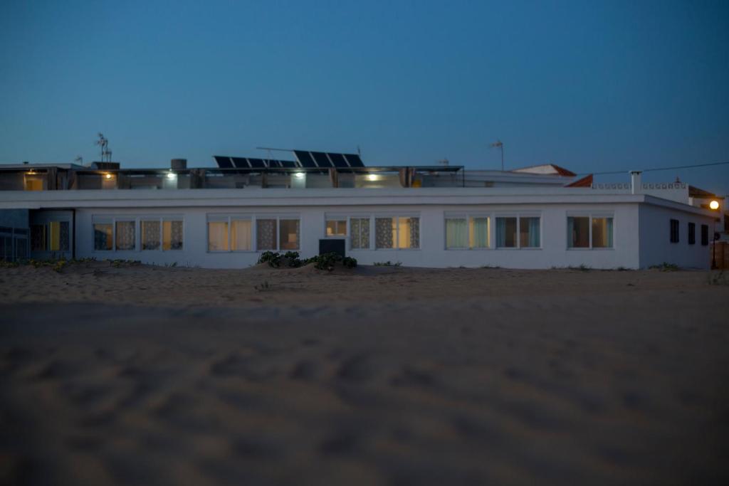 a white house on the beach at night at Apartamentos Calypso in Punta Umbría