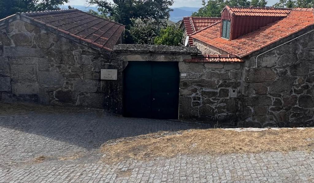 a stone building with a blue door and a roof at Casa da Costinha in Cinfães